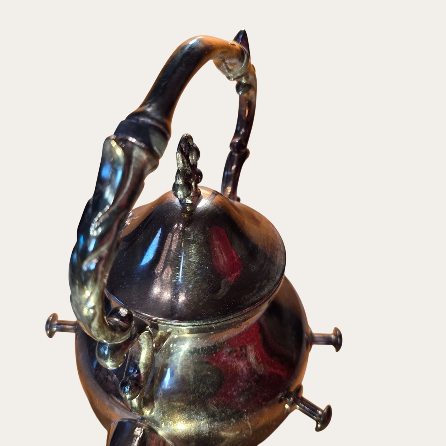 Vintage Ornate Silver-Plated Teapot With Intricate Handle Design And Hinged Lid