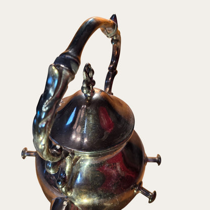 Vintage Ornate Silver-Plated Teapot With Intricate Handle Design And Hinged Lid