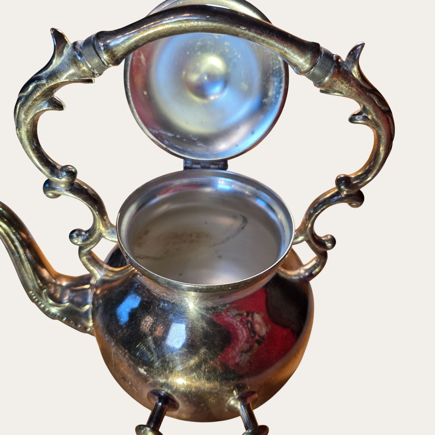 Vintage Ornate Silver-Plated Teapot With Intricate Handle Design And Hinged Lid